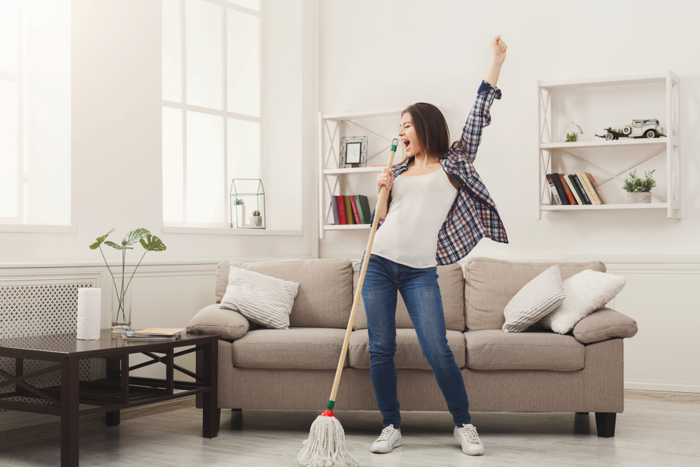 Happy,Woman,Cleaning,Home,,Singing,At,Mop,Like,At,Microphone